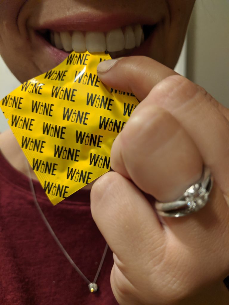Ripping open the wine condom packaging