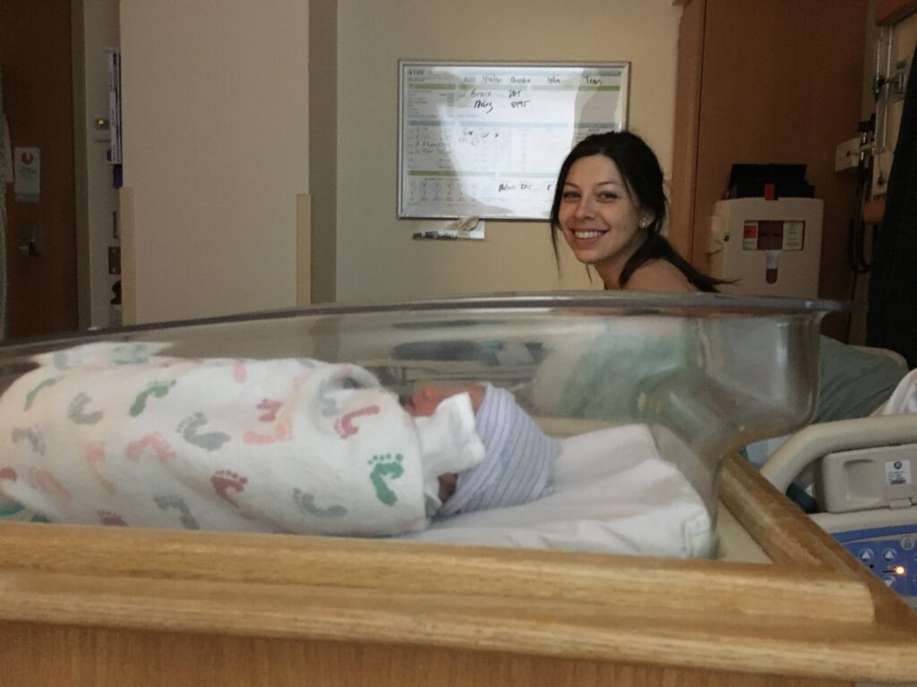 article re packing your hospital bag. image of mom and baby in hospital postpartum