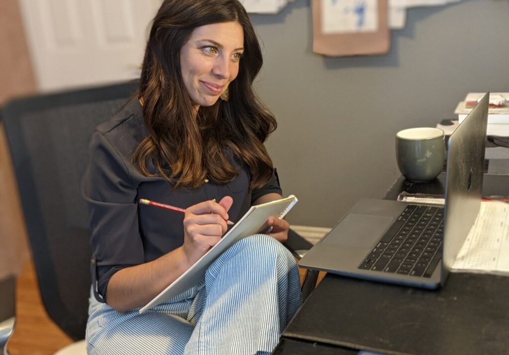 Christina taking notes during a virtual meeting